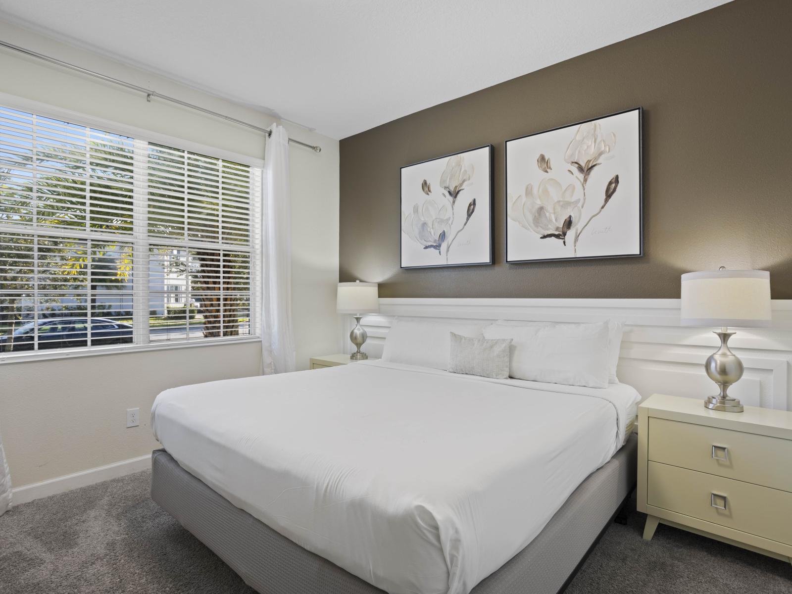 - Relax in this serene bedroom featuring a plush king-sized bed - Soft decor and natural light from window create a calming atmosphere - Perfect for restful nights with modern furnishings and tasteful art