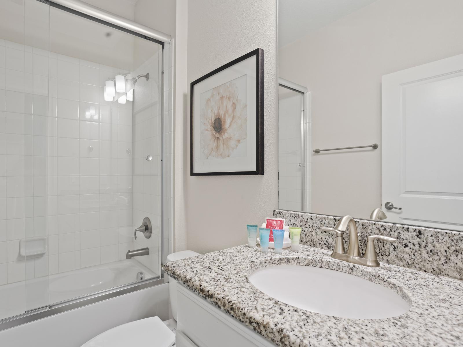 - Elegant bathroom featuring a granite countertop and sleek glass walk-in shower - Equipped with essential toiletries for your convenience and comfort - A bright, clean space perfect for refreshing after a day of activities