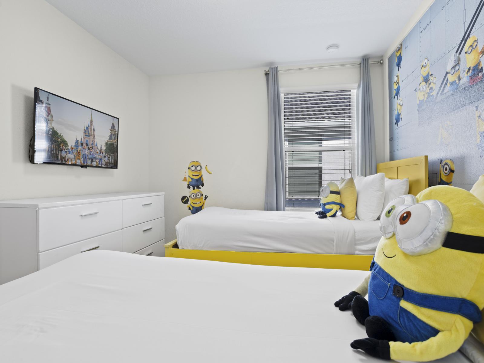 - Fun and colorful Minion-themed bedroom perfect for kids - Two comfortable twin beds with bright yellow frames - Wall-mounted TV and playful decorations enhance the cheerful atmosphere