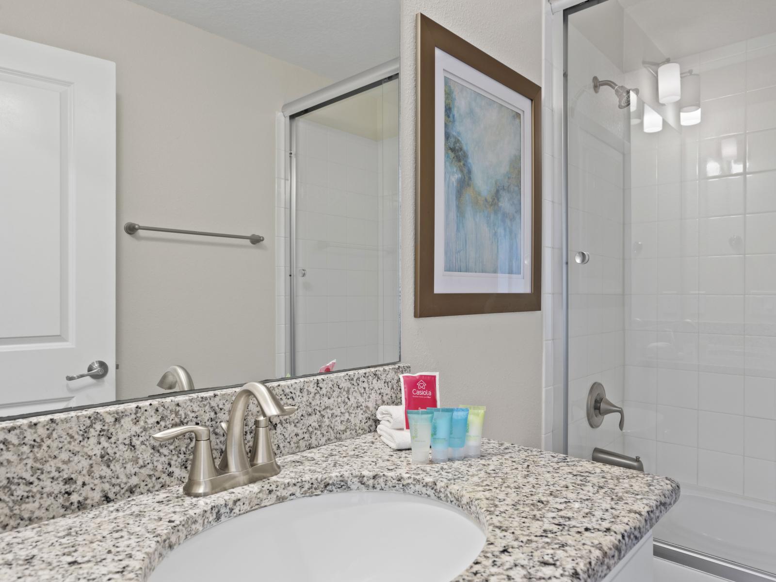 - Elegant bathroom featuring a sleek granite countertop and polished fixtures - Spacious walk-in shower with glass doors for a modern touch - Bright and clean design, perfect for unwinding after a long day