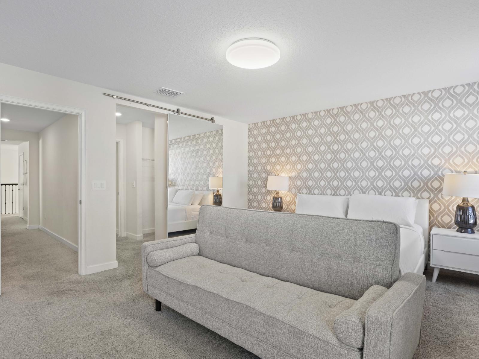 - Sophisticated bedroom with a stylish patterned accent wall and cozy seating - Bright and airy, featuring soft lighting and neutral decor - Perfect for relaxation, with plenty of space and modern furnishings