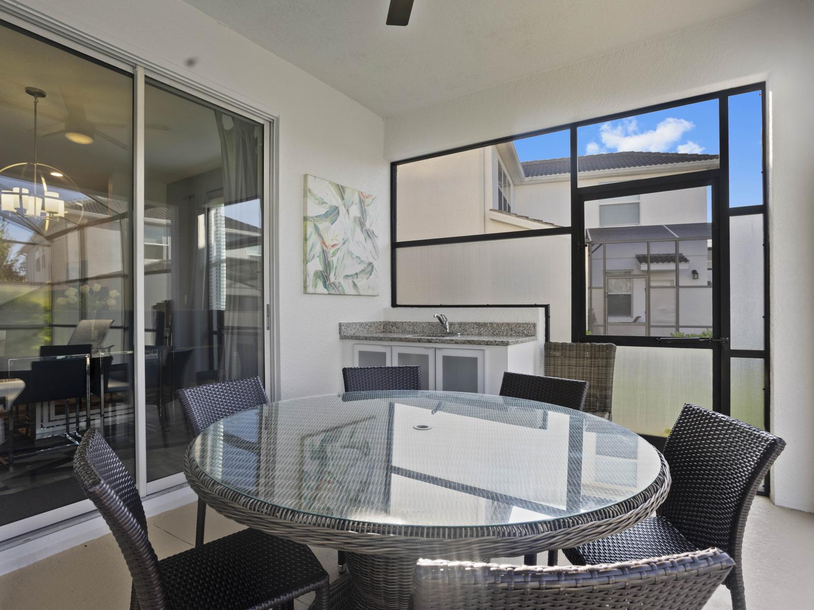 - Spacious covered outdoor dining area with a stylish glass table - Ideal for enjoying meals alfresco, featuring an outdoor sink and counter space - Perfect for family gatherings or casual outdoor dining in a serene setting