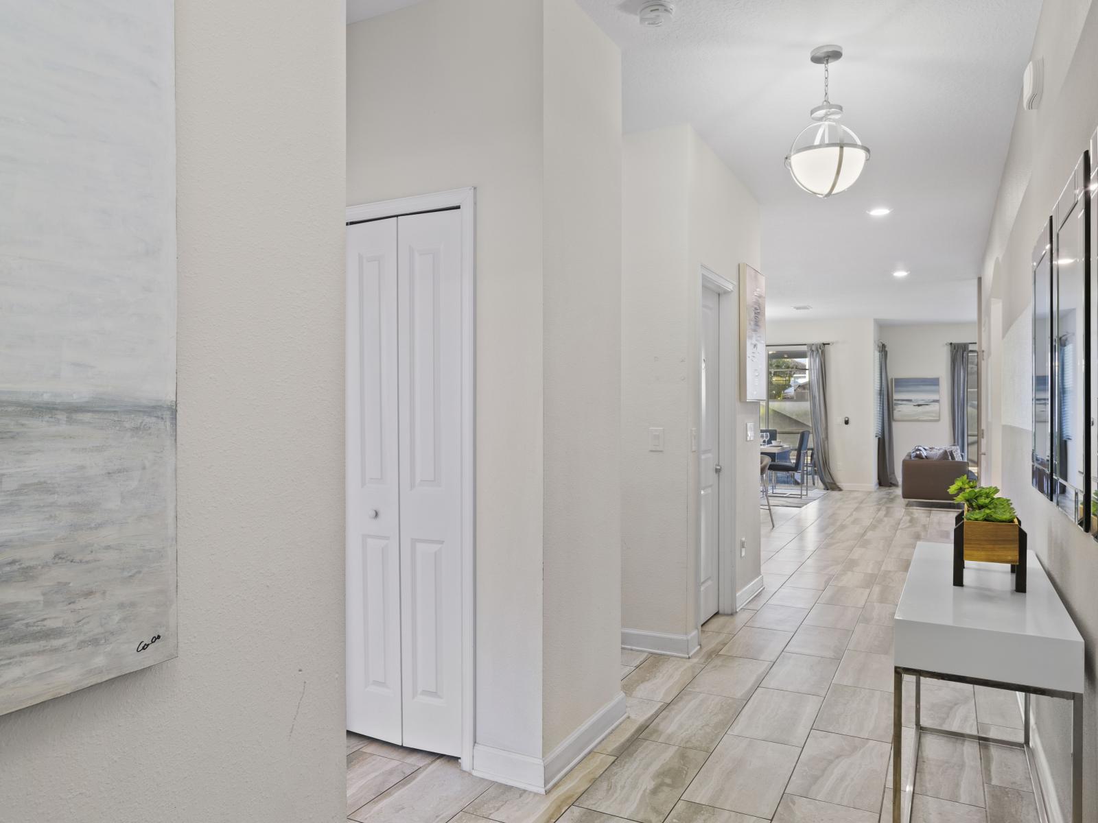 - Stylish home entrance with clean design and elegant decor - Tile flooring and neutral tones create a bright, welcoming atmosphere - Perfect first impression with chic lighting and a sleek console table