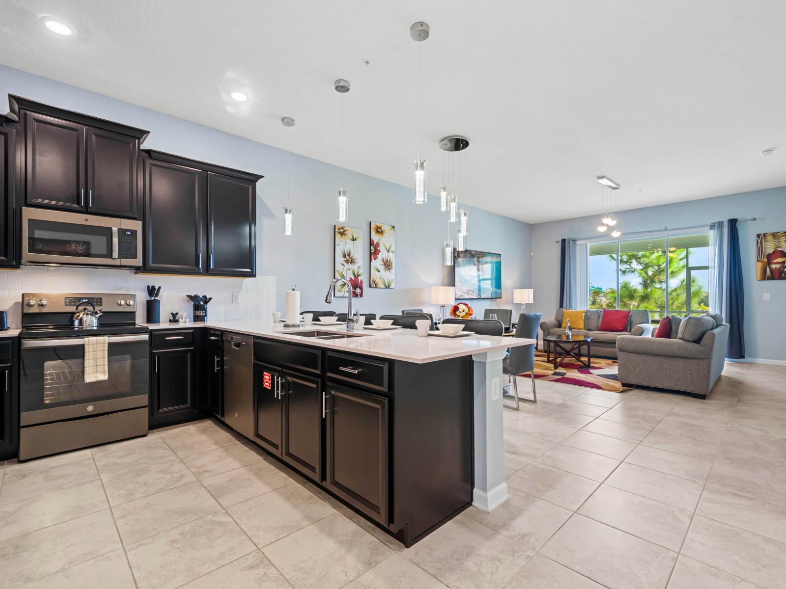 - Kitchen with a large island, offering extra counter space and casual seating - Sleek black cabinetry and stainless steel appliances provide a modern, polished look - Seamless flow into the living and dining areas, perfect for entertaining guests