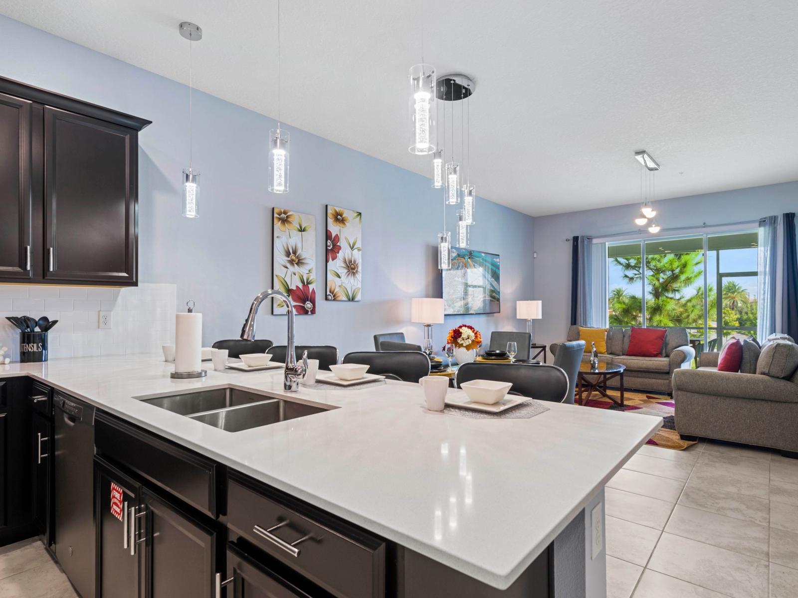 - The kitchen features a sleek island with plenty of countertop space, perfect for meal prep or casual dining - Modern pendant lighting illuminates the area, creating a stylish ambiance - Seamless flow into the living room, ideal for entertaining