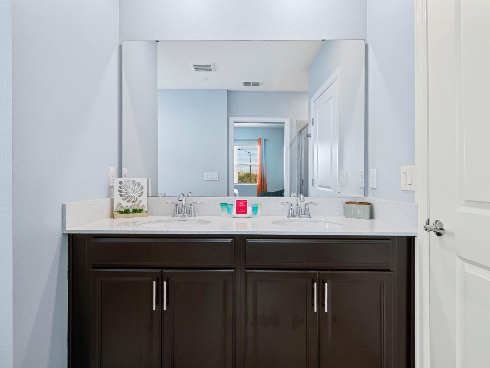 - A sleek double vanity with a large mirror and elegant modern fixtures, perfect for your daily routine   - Dark cabinetry below offering the storage space for all your essentials   - Clean, spacious, and contemporary bathroom design for relaxation