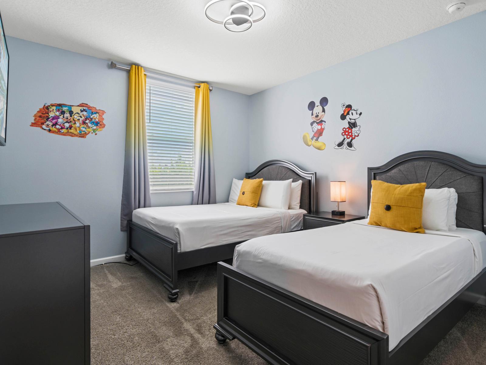 - Bedroom features a cozy setup with one double bed and one single bed - Bright and fun décor with Disney-themed wall art, creating a playful ambiance  - Equipped with a flat-screen TV, dresser, and soft carpet flooring for a comfortable stay