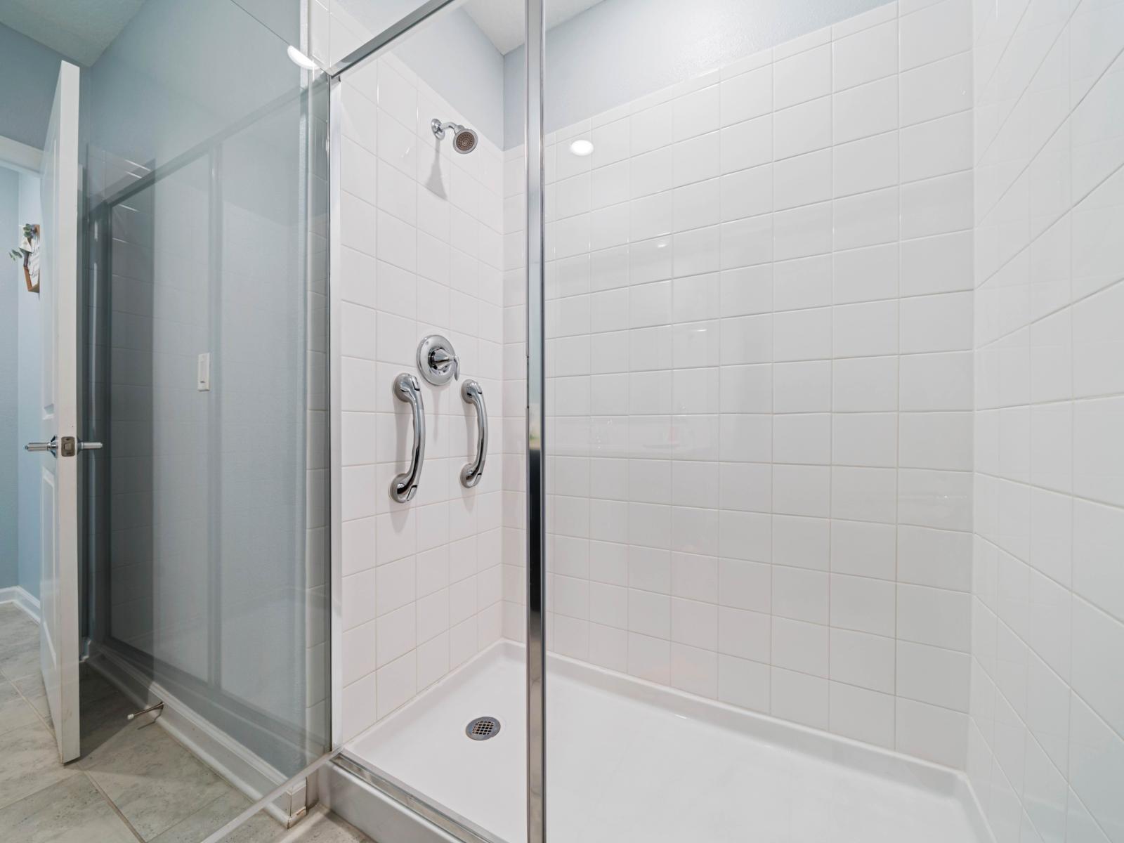 - Step into a spacious walk-in shower featuring modern glass doors and sleek tilework - Convenient grab bars for added safety and comfort while you unwind - A refreshing space for your daily routine, perfect for a rejuvenating start to your day