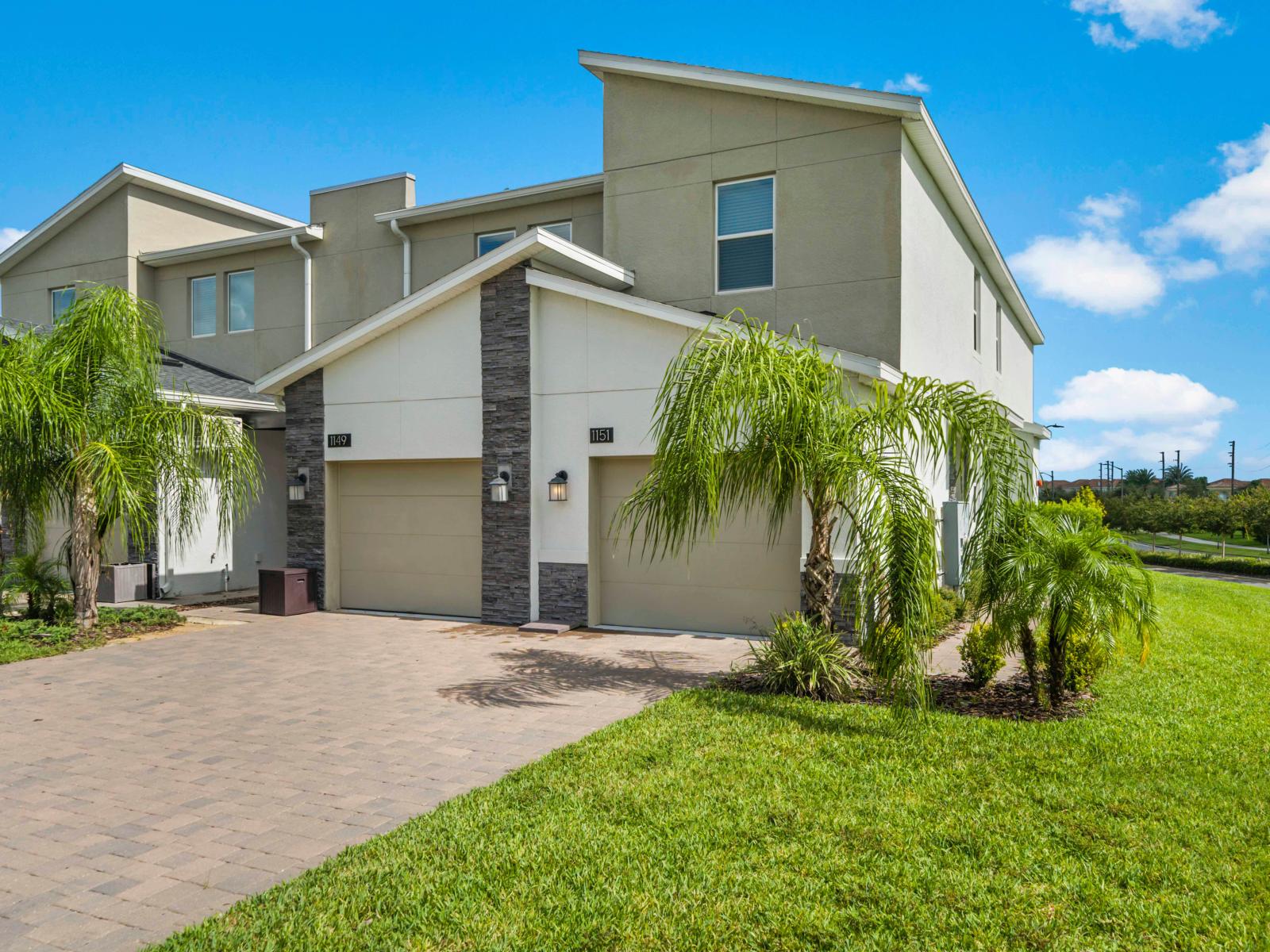 Modern condo with sleek design, private garage, and palm-lined front yard, perfect for a peaceful retreat.