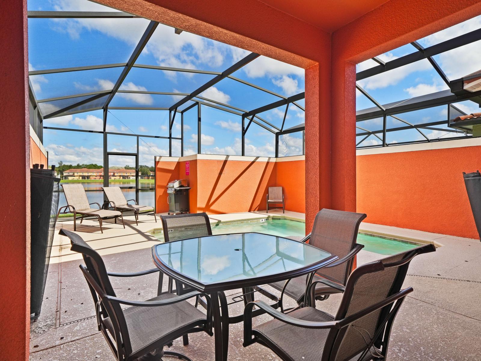 - Inviting outdoor patio with a covered dining area, perfect for enjoying meals by the pool - Private screened pool, lounge chairs offer a relaxing retreat under the sun - Bright orange walls and a BBQ grill add warmth and functionality to the space