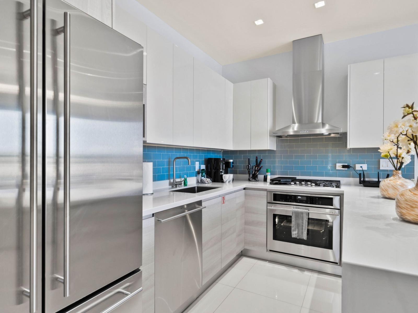 - Contemporary kitchen with generous appliances and a built-in oven - Features a gas stove, dishwasher and a roomy fridge for all your groceries - Blue tile backsplash adds a splash of color to the sleek white cabinets