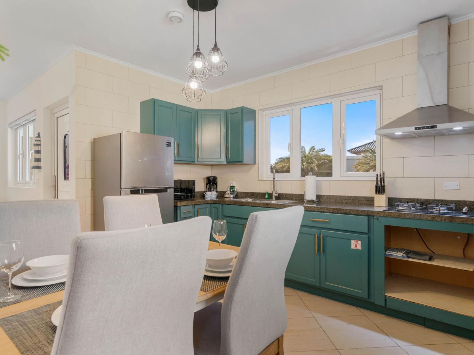 - Prepare meals in a fully equipped kitchen with chic teal cabinets and modern appliances - Enjoy the seamless connection between cooking and dining, perfect for family meals - Bright and inviting space for creating delicious moments together