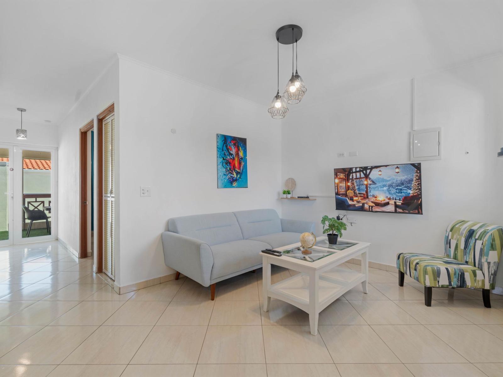 - Bright and modern living room with a cozy sofa and vibrant, artistic decor - Perfect for unwinding after a day of adventure, featuring a flat-screen TV for entertainment - Enjoy natural light streaming in, creating a welcoming and airy atmosphere