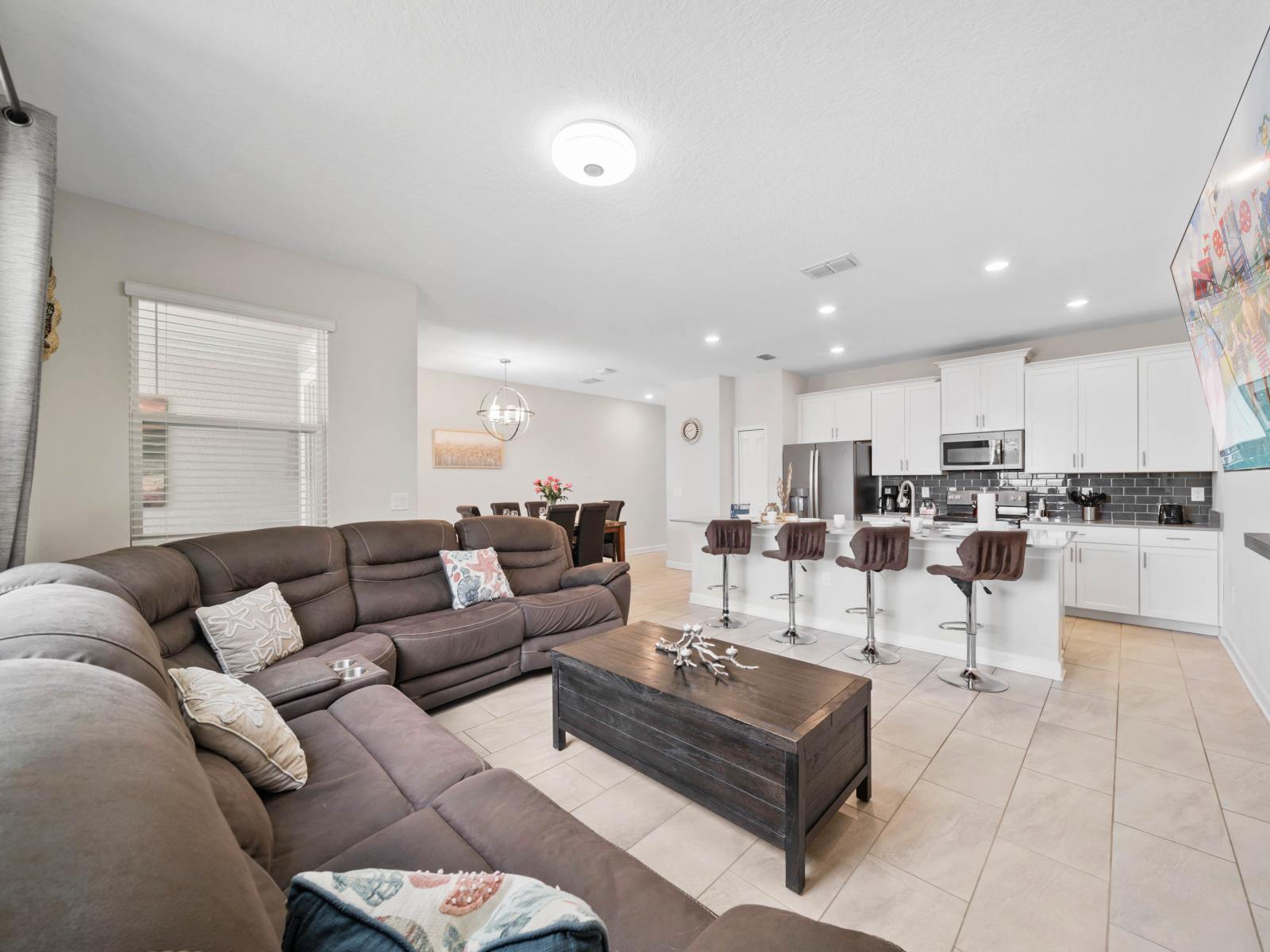 Enjoy a movie night in this inviting living space, equipped with a large screen and comfortable seating.