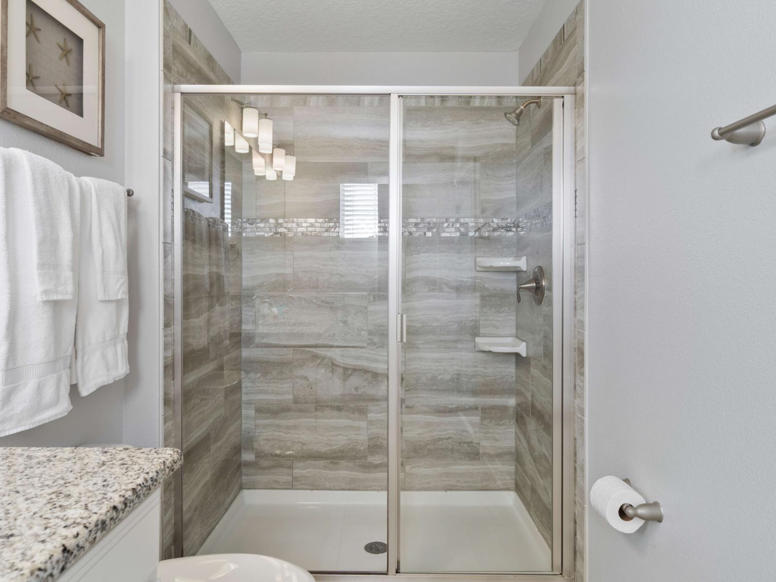 En-Suite Bathroom:  Step into your private en-suite with a glass-enclosed walk-in shower, quality toiletries, and plush towels, making mornings a breeze.