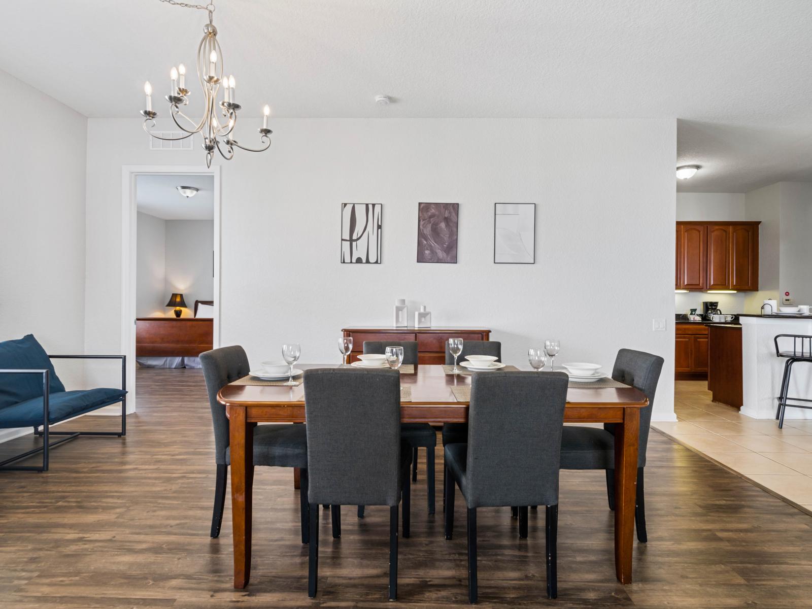 - Dining space with a beautiful wooden table set for six, ready for family meals - Open layout, it connects seamlessly to the kitchen & living areas for easy hosting - Charming chandelier & natural light, creating a warm & welcoming atmosphere