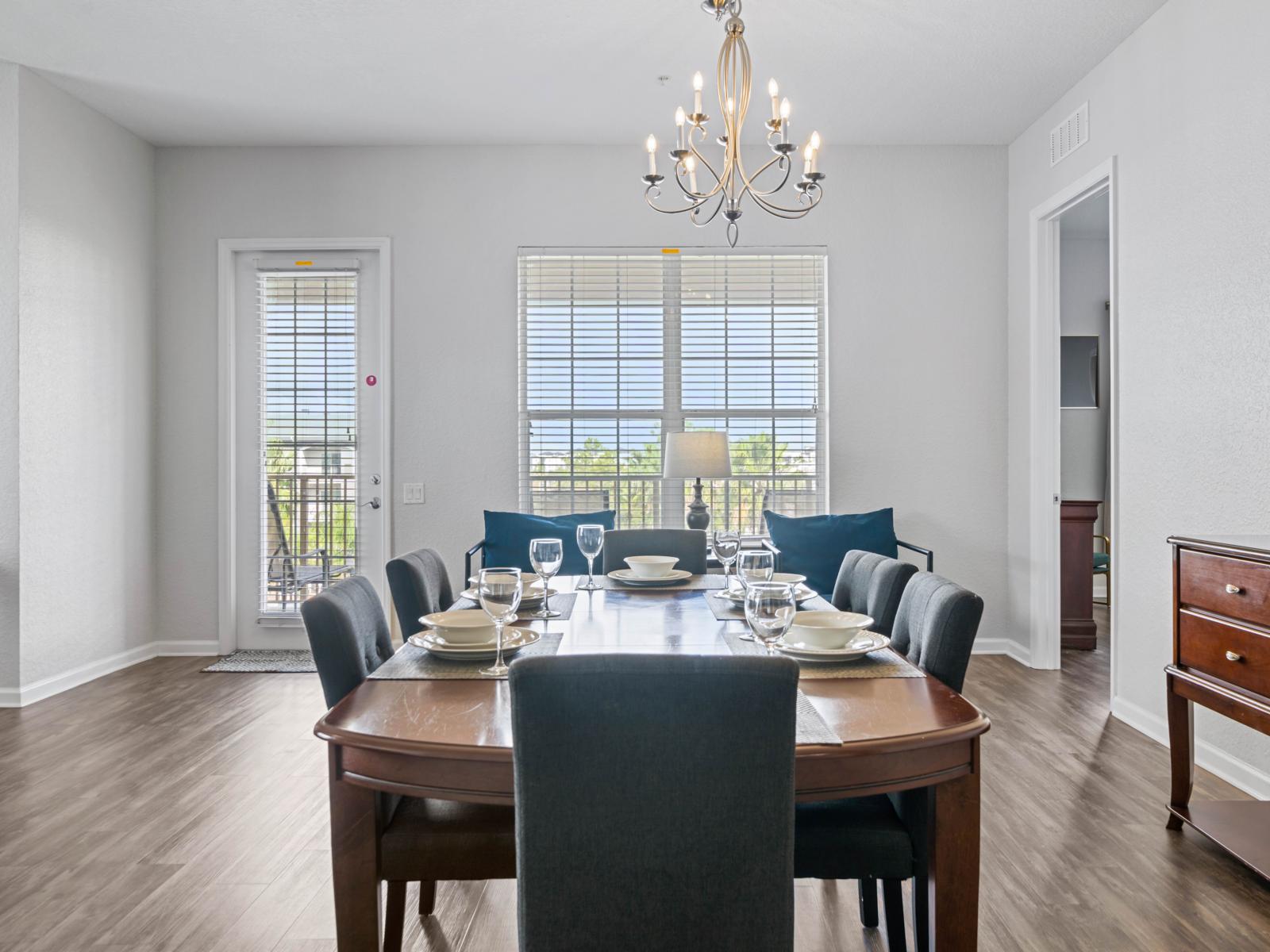 - Bright & inviting dining space with a beautifully set table for family meals or gatherings - Large windows & balcony access provide a serene view & plenty of natural light - Elegant & comfortable seating make this space perfect for special moments