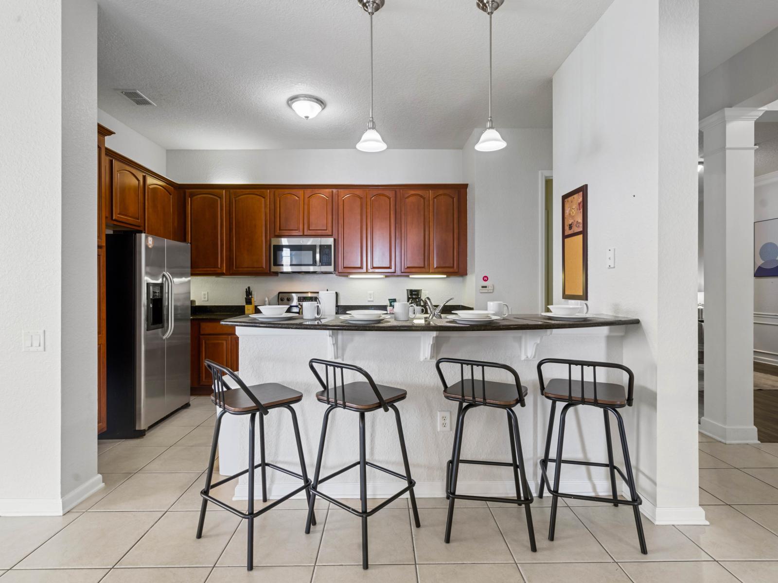 - Spacious kitchen with a sleek breakfast bar, complete with seating for four - Features stainless steel appliances, granite countertops, and plenty of cabinet space - Perfect for enjoying quick meals or chatting with loved ones while preparing food