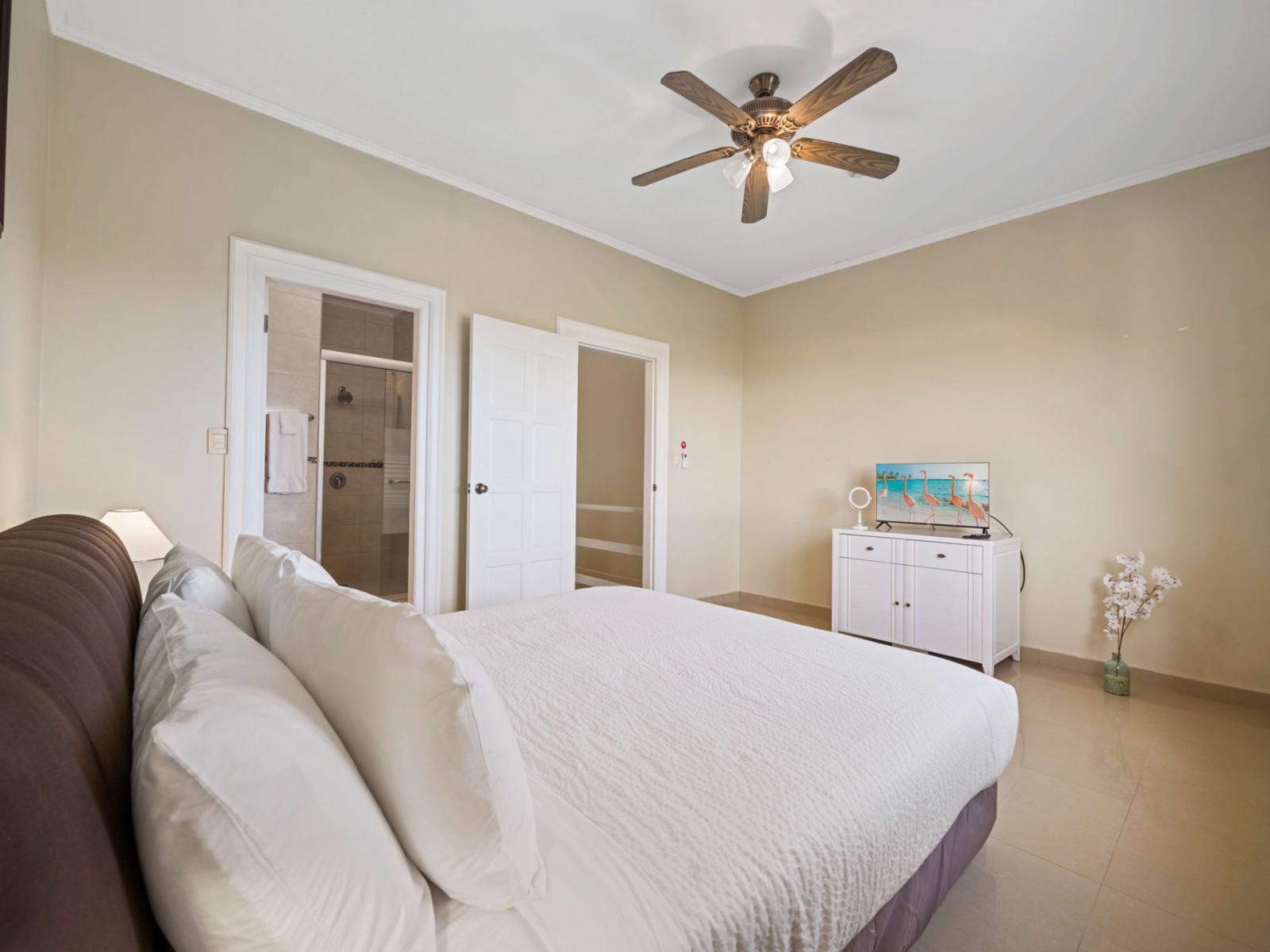 Relax in the luxurious second bedroom with a king-sized bed, smart TV, ensuite bathroom, and a window view that fills the space with natural light – the perfect Airbnb retreat!