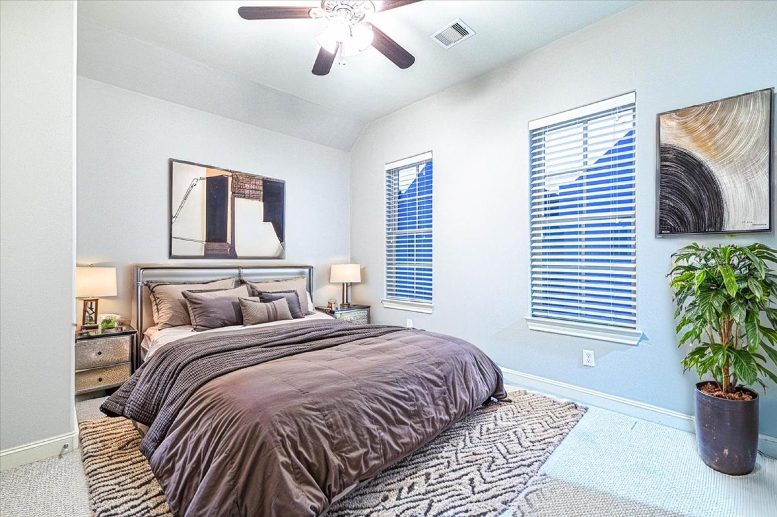 Bedroom 2 on the 3rd floor with a queen size bed, ceiling fan, 65" smart TV and en-suite bathroom