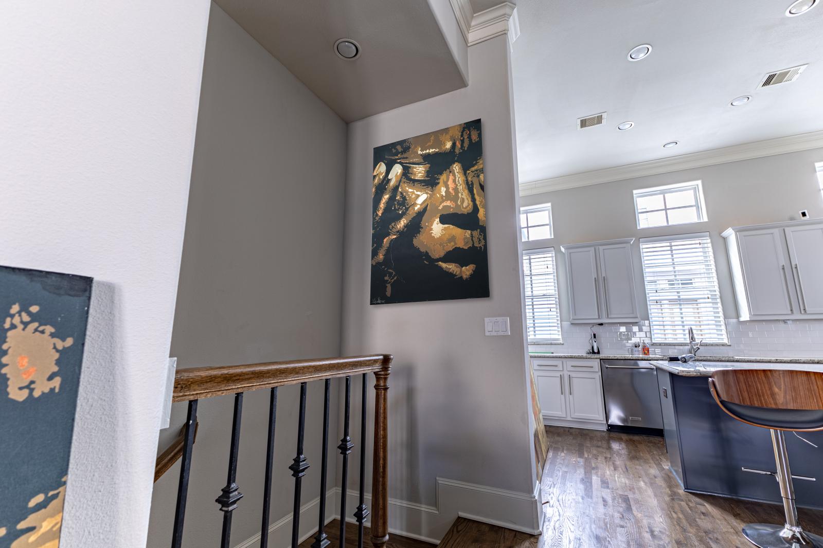 Ascend to the 2nd floor, greeted by modern art and stylish design with a sleek blend of wood, metal sets the tone for a sophisticated stay. Just beyond, a bright, open kitchen awaits—perfect for gathering and relaxing.