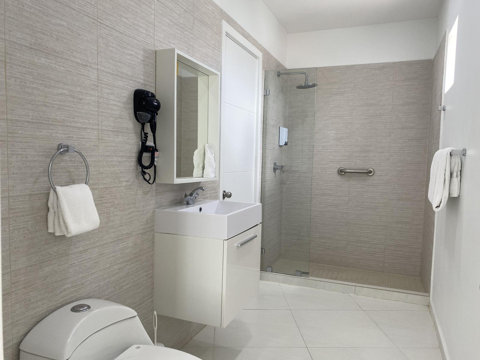 Step into a spotless, modern bathroom designed for relaxation and comfort - Enjoy a refreshing shower in the spacious walk in design with exclusive amenities - Fresh towels, a hairdryer, and all essentials are provided, just bring yourself