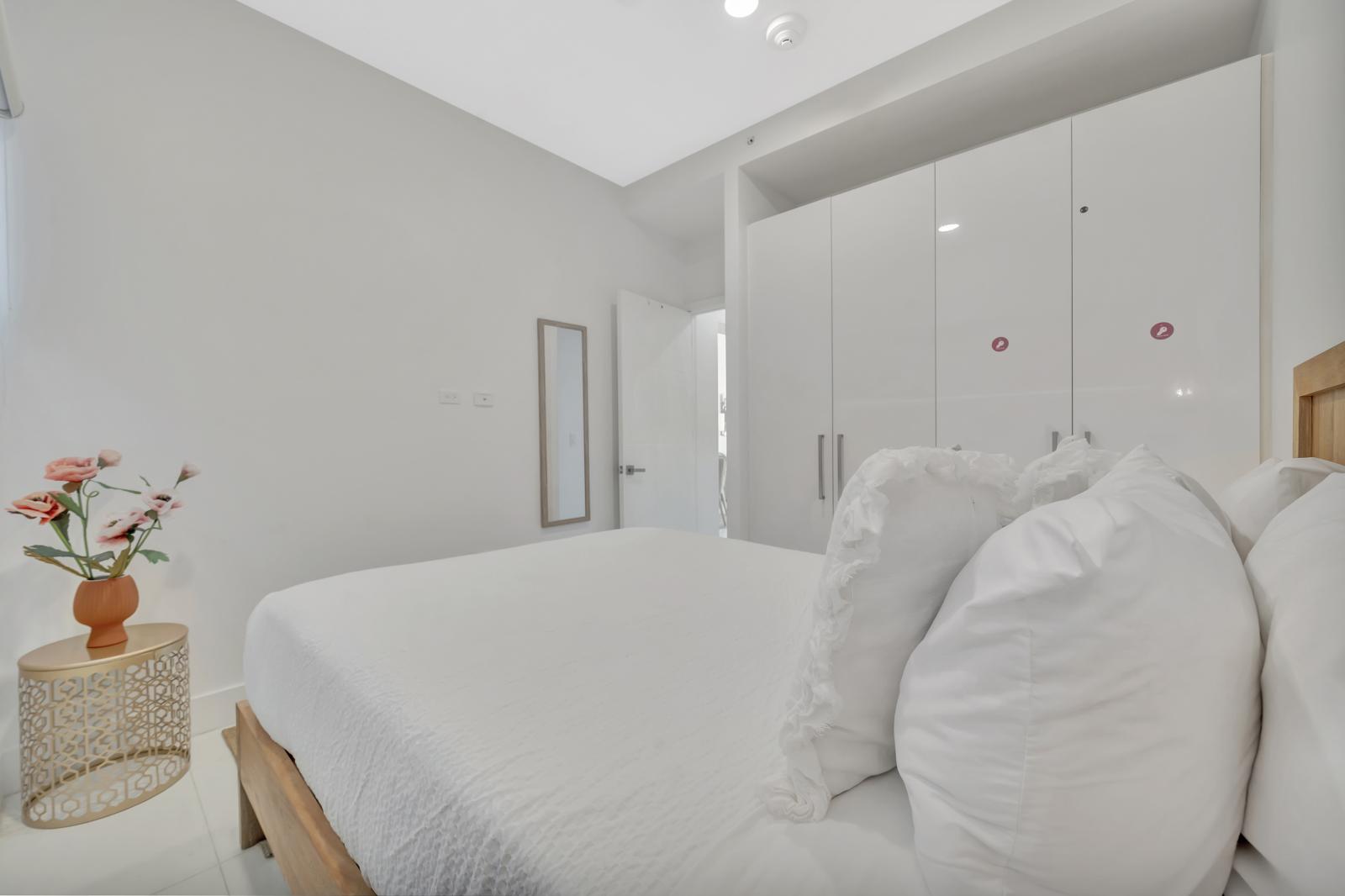 Cozy queen-size bed, wrapped in soft linens for the perfect night’s sleep - Warm lighting and soothing blue accents create a calm and inviting atmosphere - Peaceful retreat where you can unwind, relax, and recharge for your next adventure