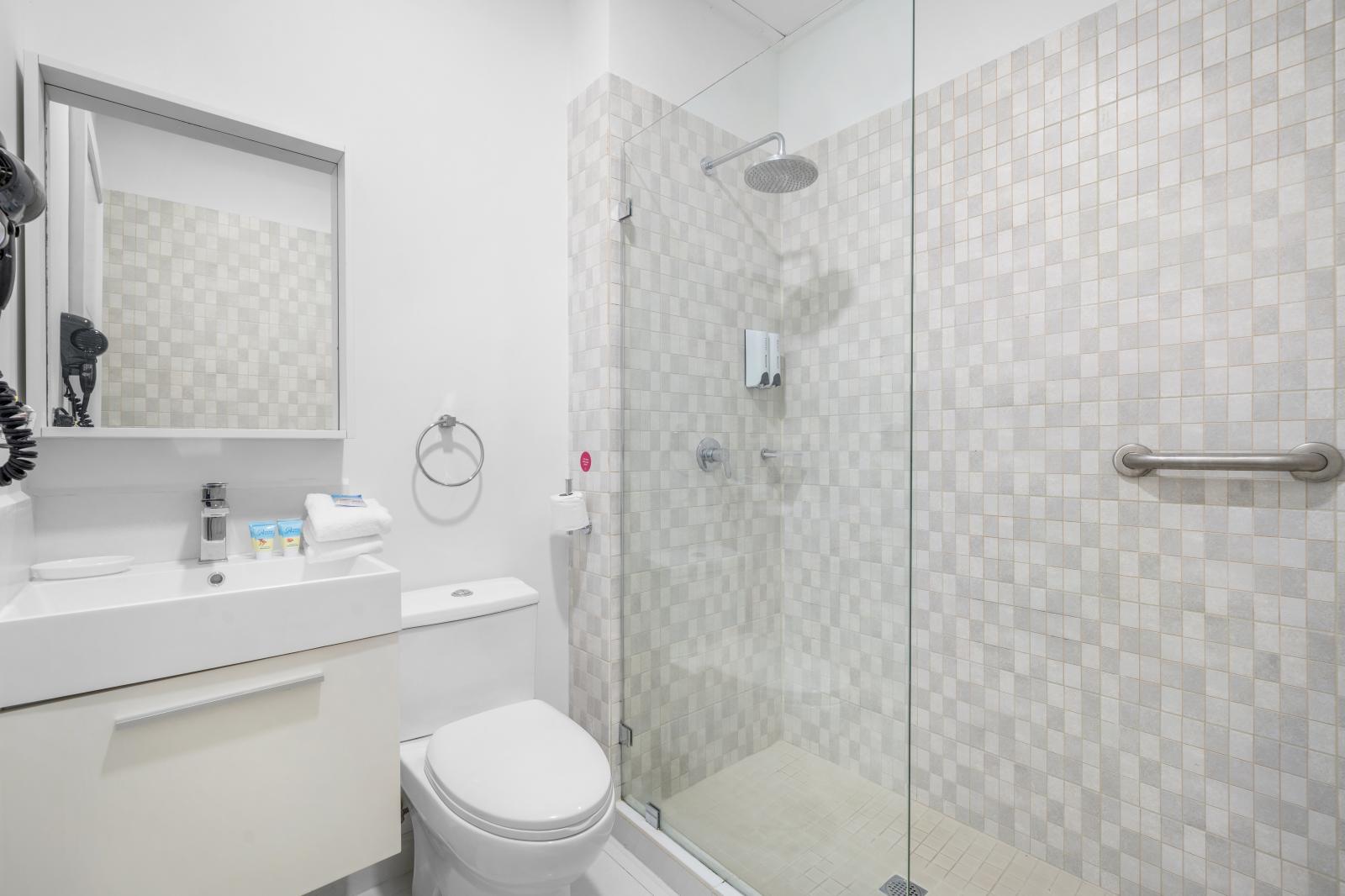 Refresh in this clean and modern bathroom featuring a spacious glass-enclosed shower - Soft towels and essential toiletries are thoughtfully provided for your convenience - Bright, well-designed space to start or end your day with ease and comfort