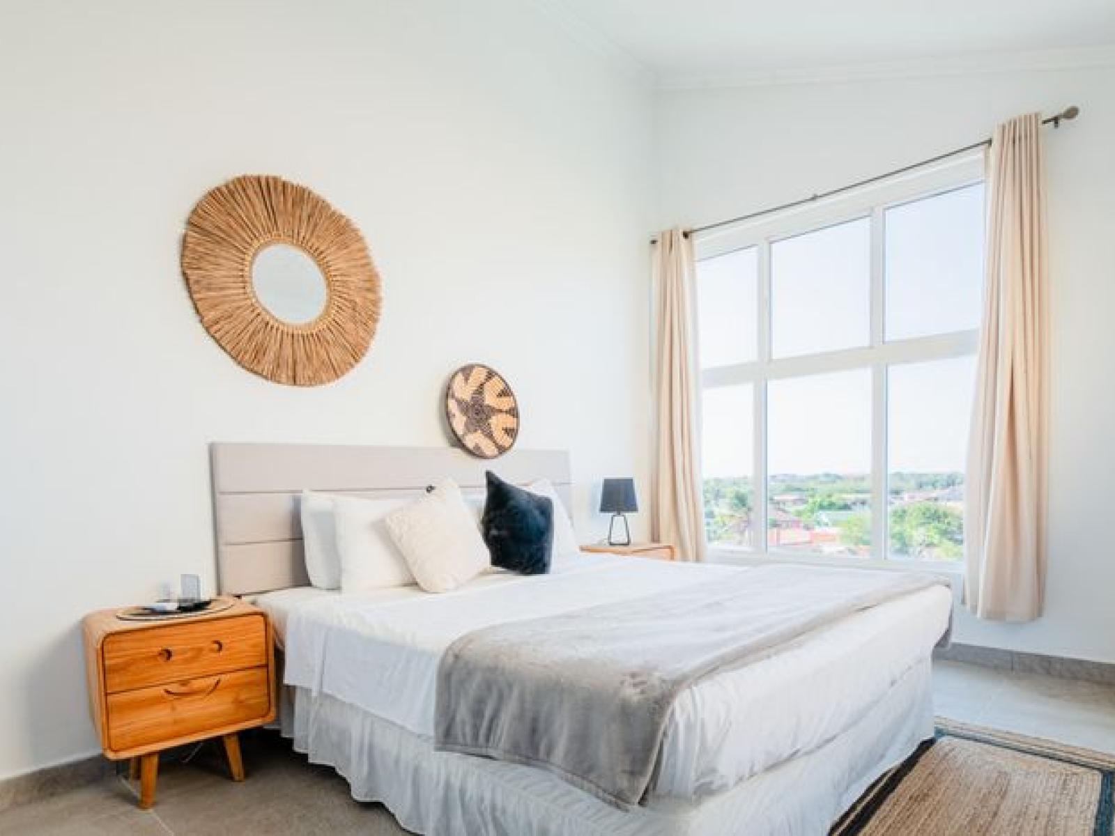 Bedroom features a king size bed and plenty of natural light through the big windows