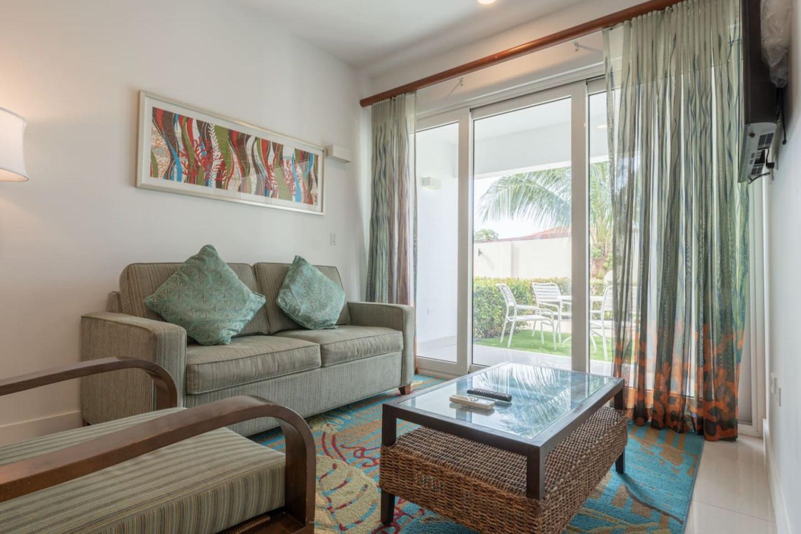 Relax in this cozy living area with inviting seating and island inspired decor - Sliding doors open to a refreshing outdoor patio, bringing in Aruba’s breeze - Perfect retreat after exploring Noord’s stunning beaches, dining, and shops