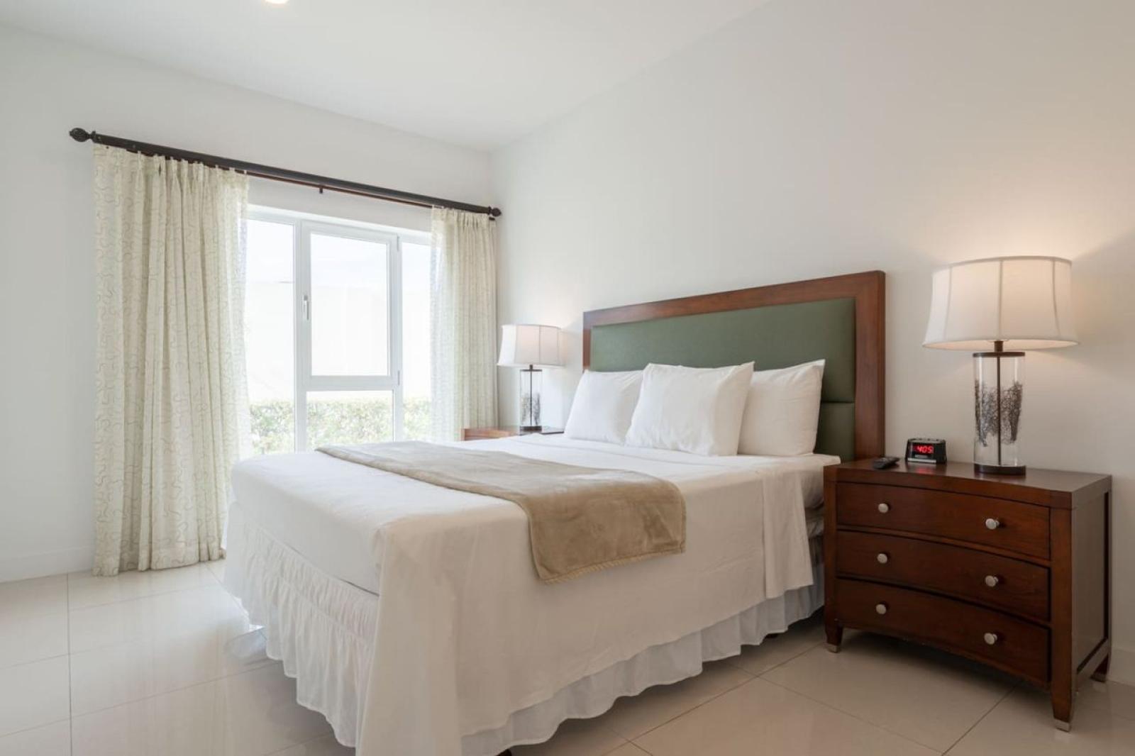 Rest peacefully in this bright bedroom featuring a cozy queen bed & calming decor - Large windows bring in natural light, creating a fresh & relaxing atmosphere - Perfect retreat to recharge after enjoying Noord’s beaches, dining, & nightlife