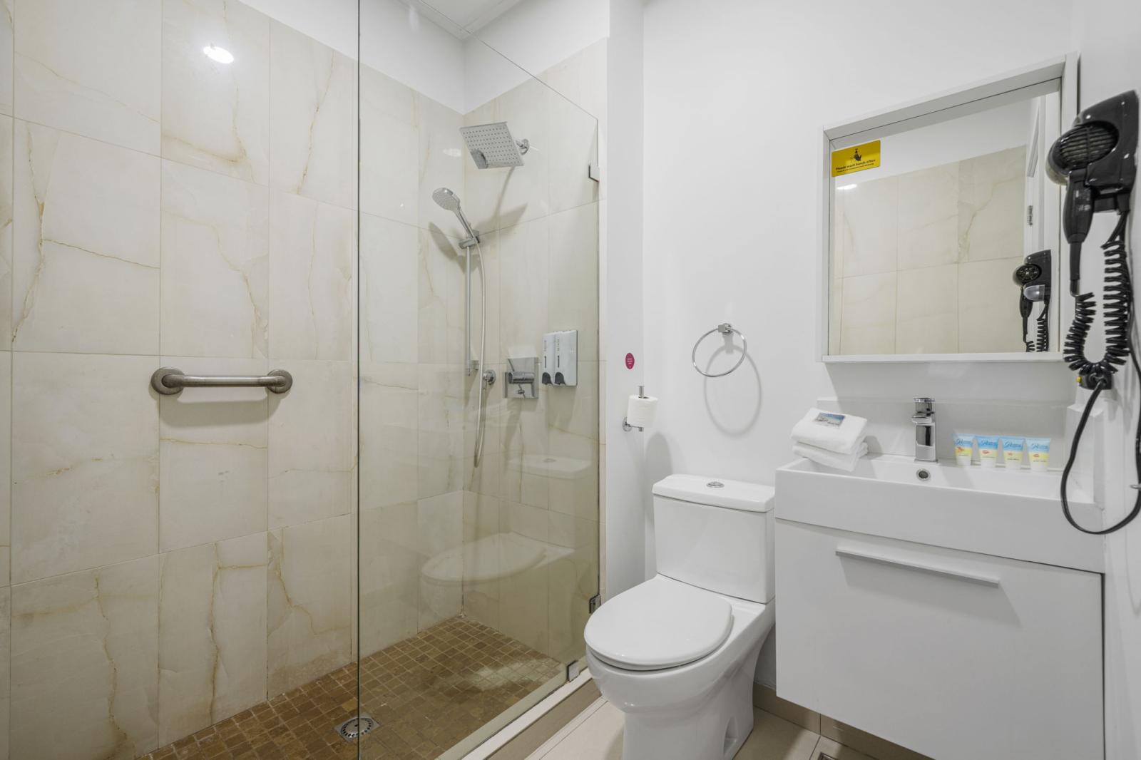 Refresh yourself in this elegant rainfall shower surrounded by sleek glass - Spotless, modern & inviting, making every shower feel like a spa retreat - Indulge in hotel quality comfort with stylish details, elite amenities, and thoughtful design