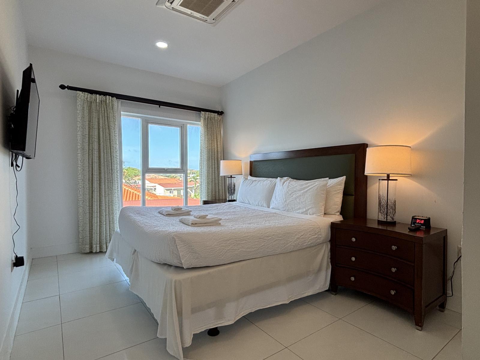 Unwind in this cozy queen size bed, wrapped in crisp, hotel quality linens - Wake up to breathtaking views through large windows that fill the room with natural light - Serene retreat with warm lighting & elegant decor, perfect for relaxation