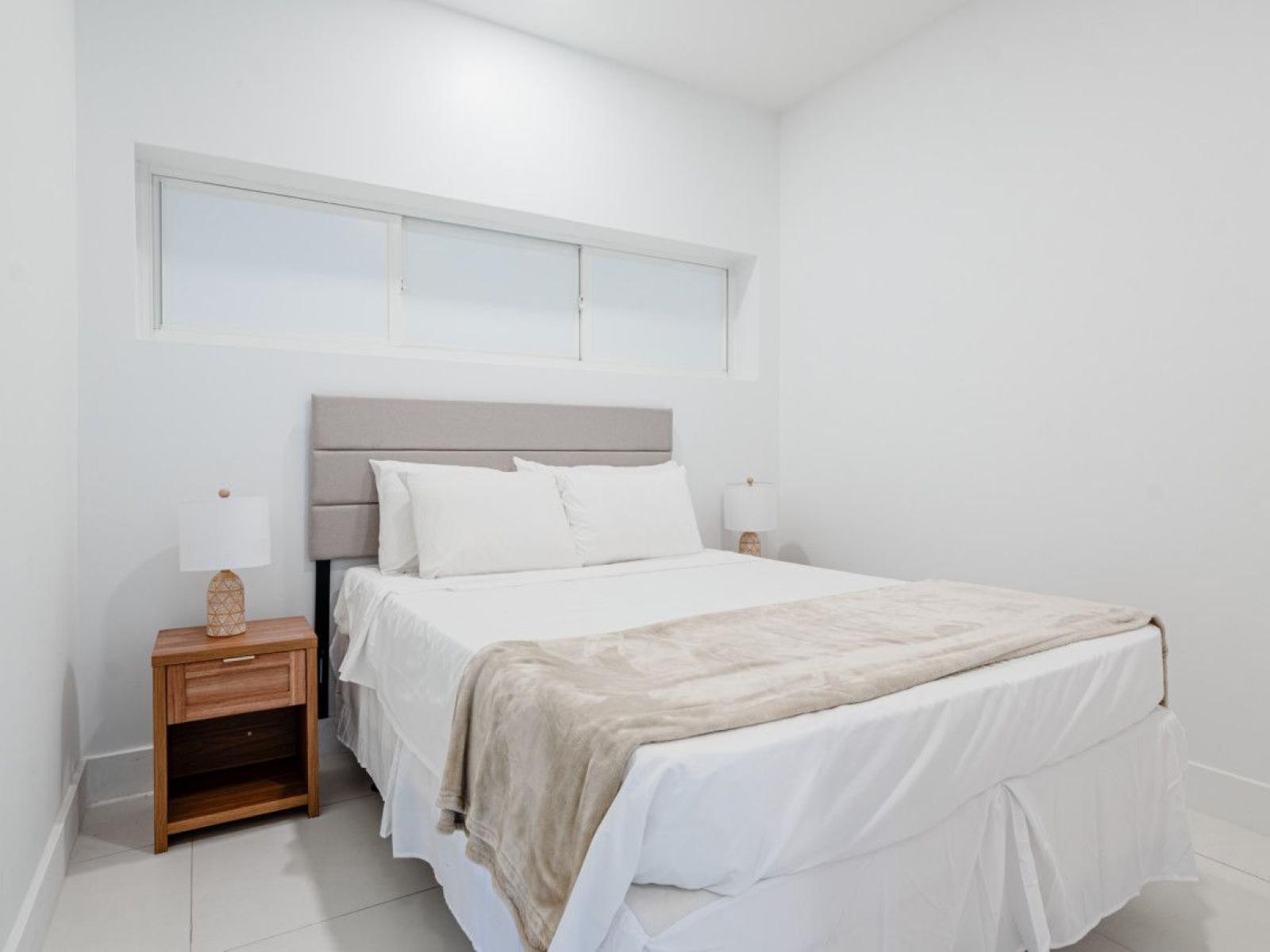 bedroom 1 with a queen size bed and high ceilings