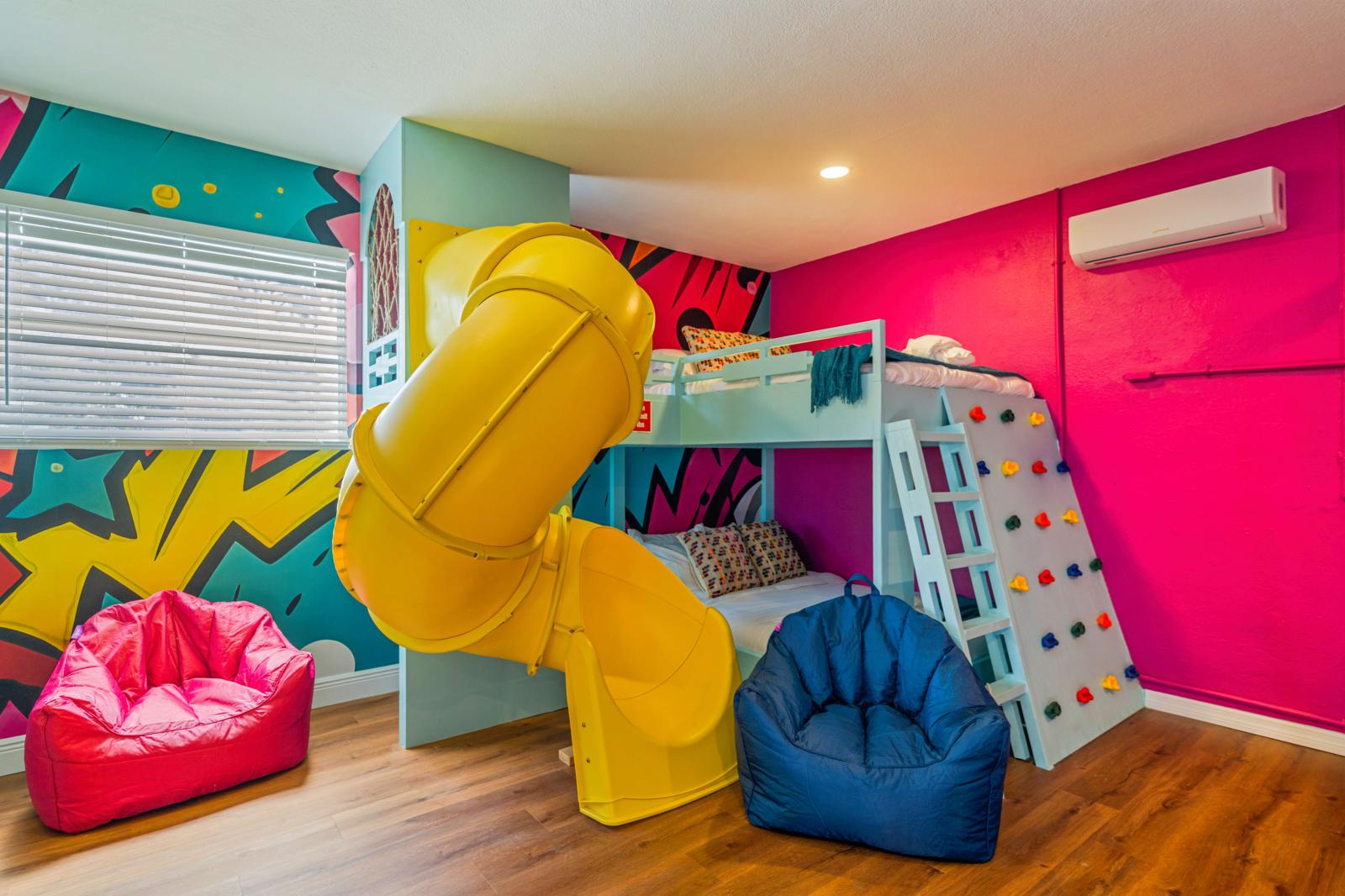 Ultimate kids' paradise featuring two double-over-double bunk beds with a slide, a fun climbing wall, an exciting air hockey table, and a thrilling basketball game!