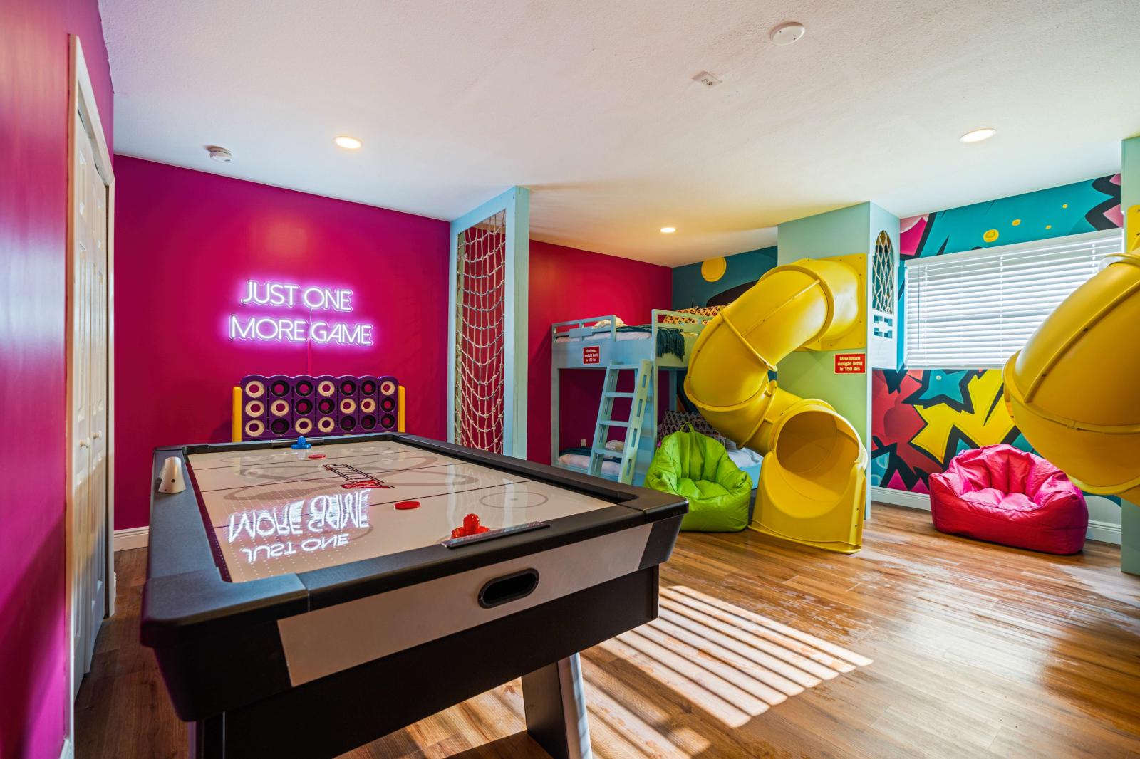 Ultimate kids' paradise featuring two double-over-double bunk beds with a slide, a fun climbing wall, an exciting air hockey table, and a thrilling basketball game!