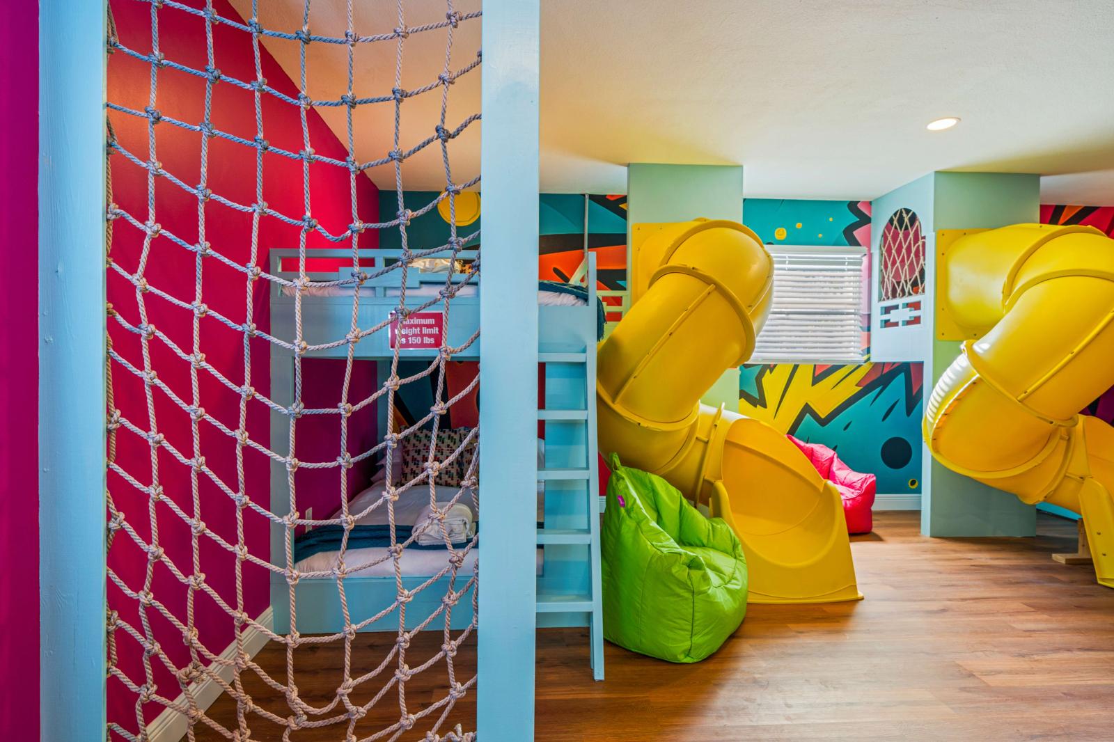 Ultimate kids' paradise featuring two double-over-double bunk beds with a slide, a fun climbing wall, an exciting air hockey table, and a thrilling basketball game!