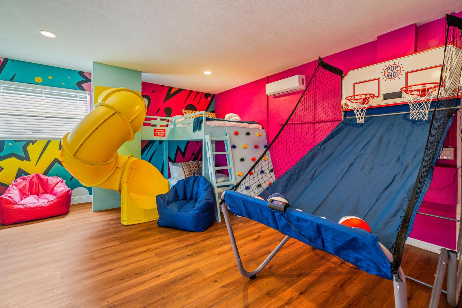 Ultimate kids' paradise featuring two double-over-double bunk beds with a slide, a fun climbing wall, an exciting air hockey table, and a thrilling basketball game!