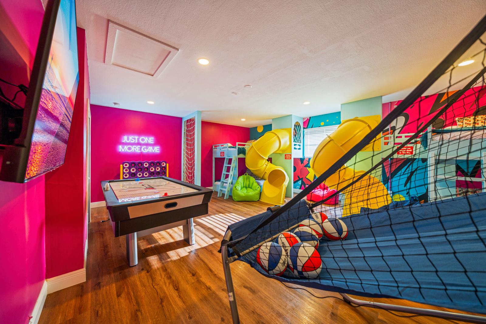 Ultimate kids' paradise featuring two double-over-double bunk beds with a slide, a fun climbing wall, an exciting air hockey table, and a thrilling basketball game!