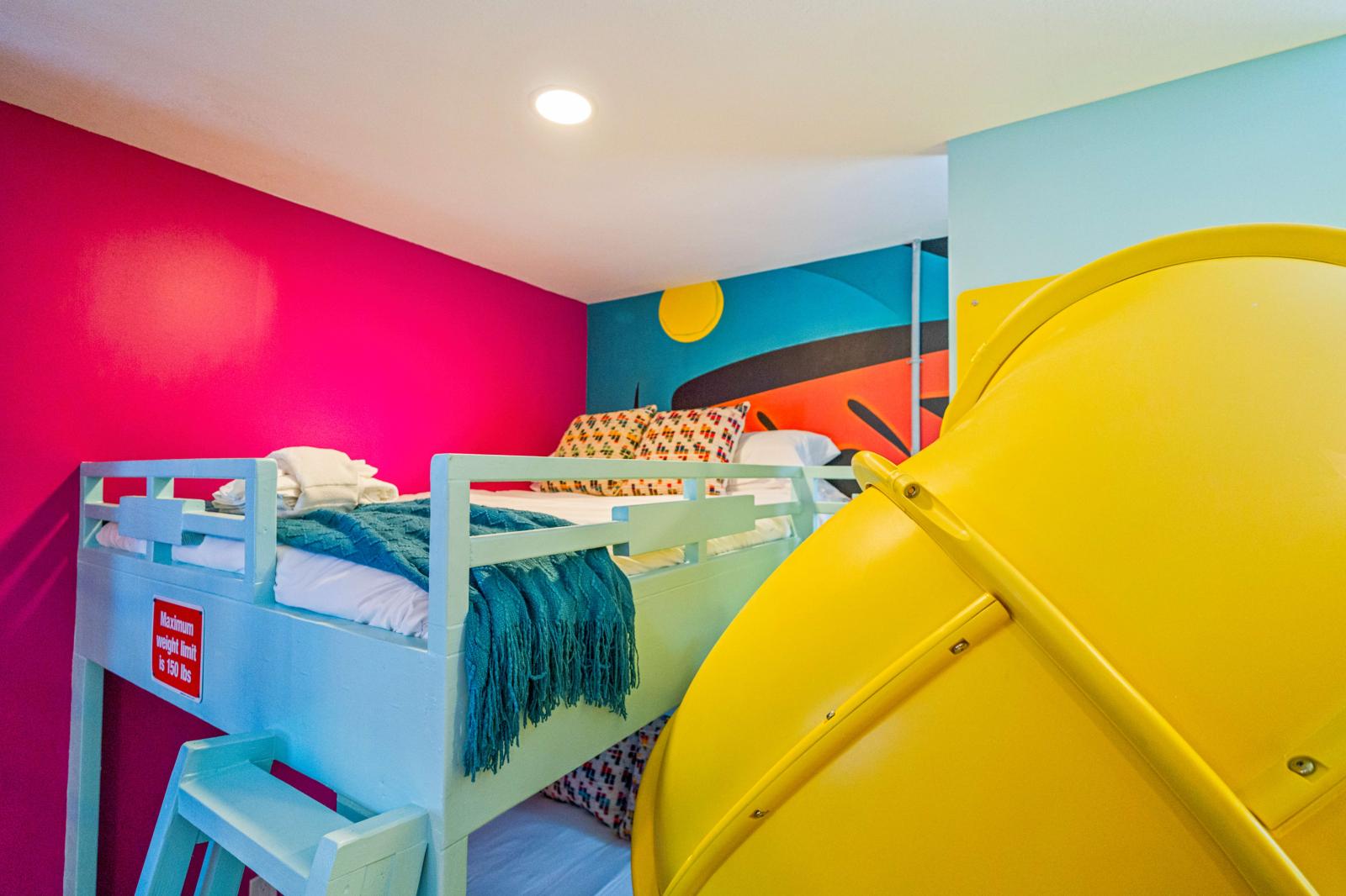 Ultimate kids' paradise featuring two double-over-double bunk beds with a slide, a fun climbing wall, an exciting air hockey table, and a thrilling basketball game!