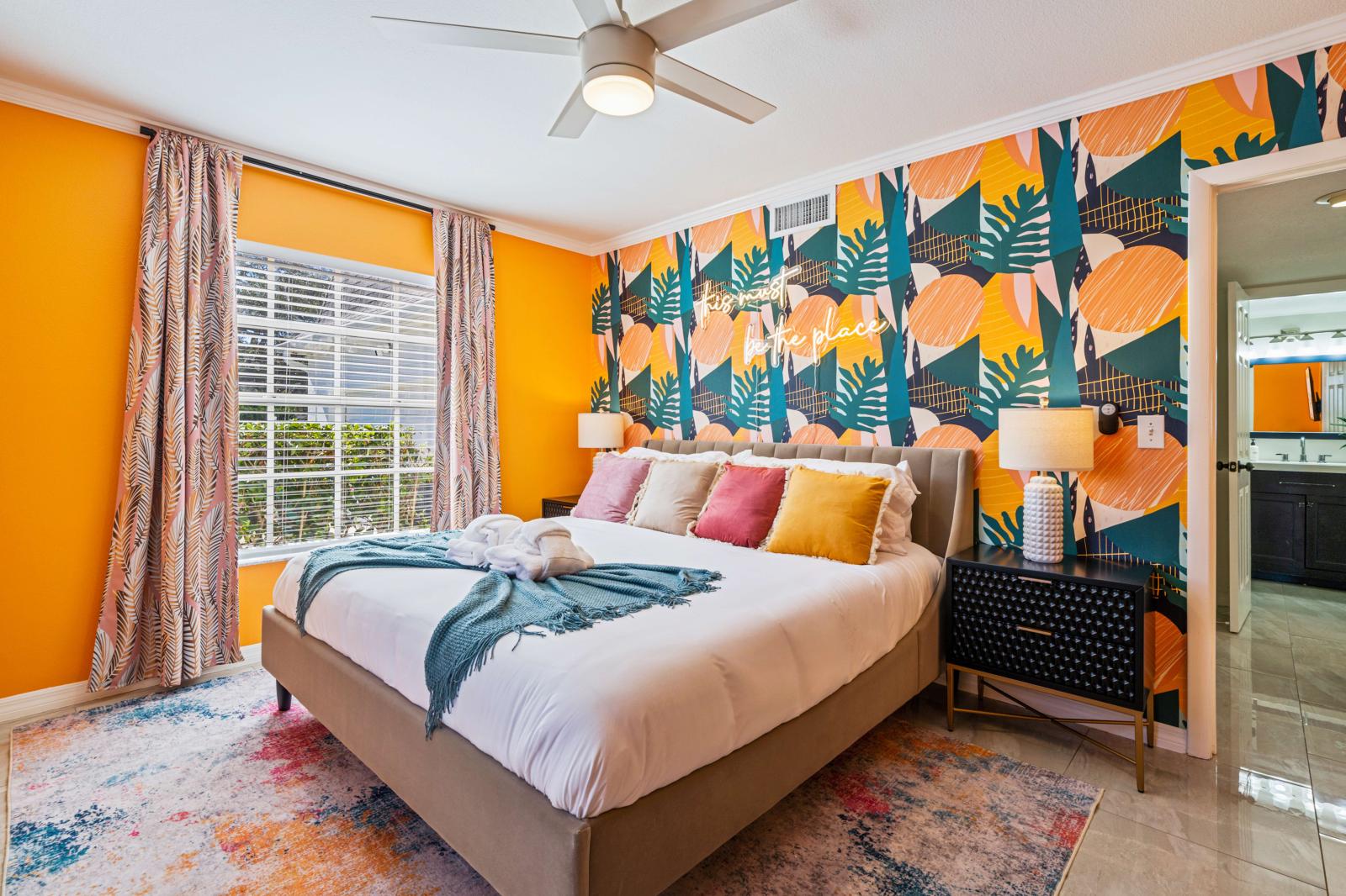 Bedroom 2: Ground-floor bedroom featuring a king-size bed, en-suite bathroom, a refreshing ceiling fan, and a large 65" smart TV for ultimate comfort and convenience.