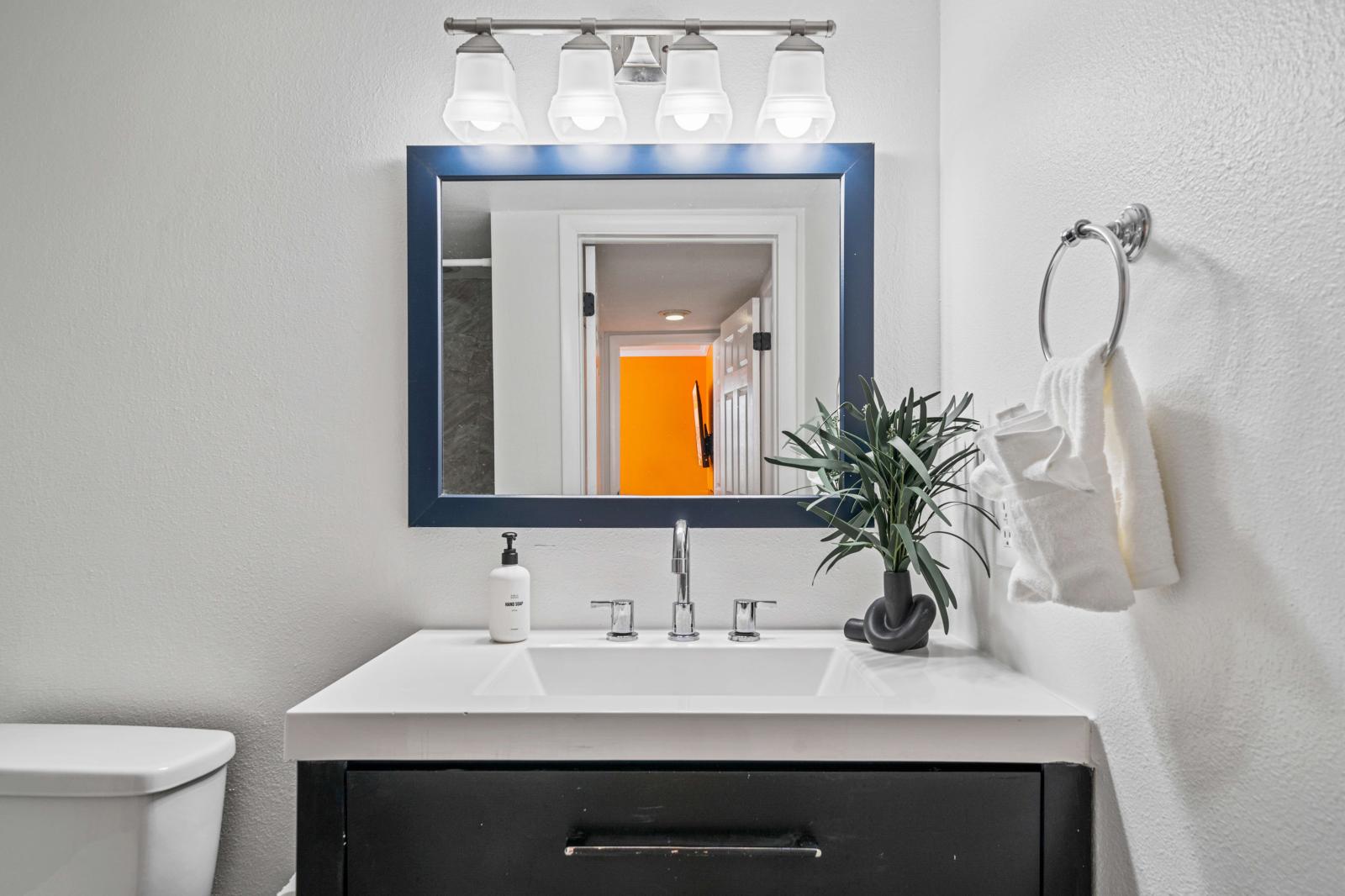 Bathroom 2: shower, toilet, and a stylish vanity sink.