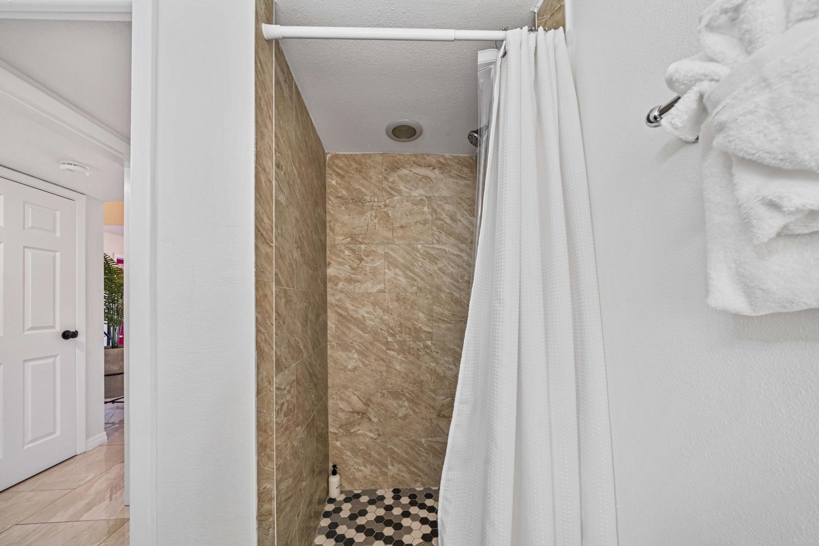 Bathroom 2: shower, toilet, and a stylish vanity sink.