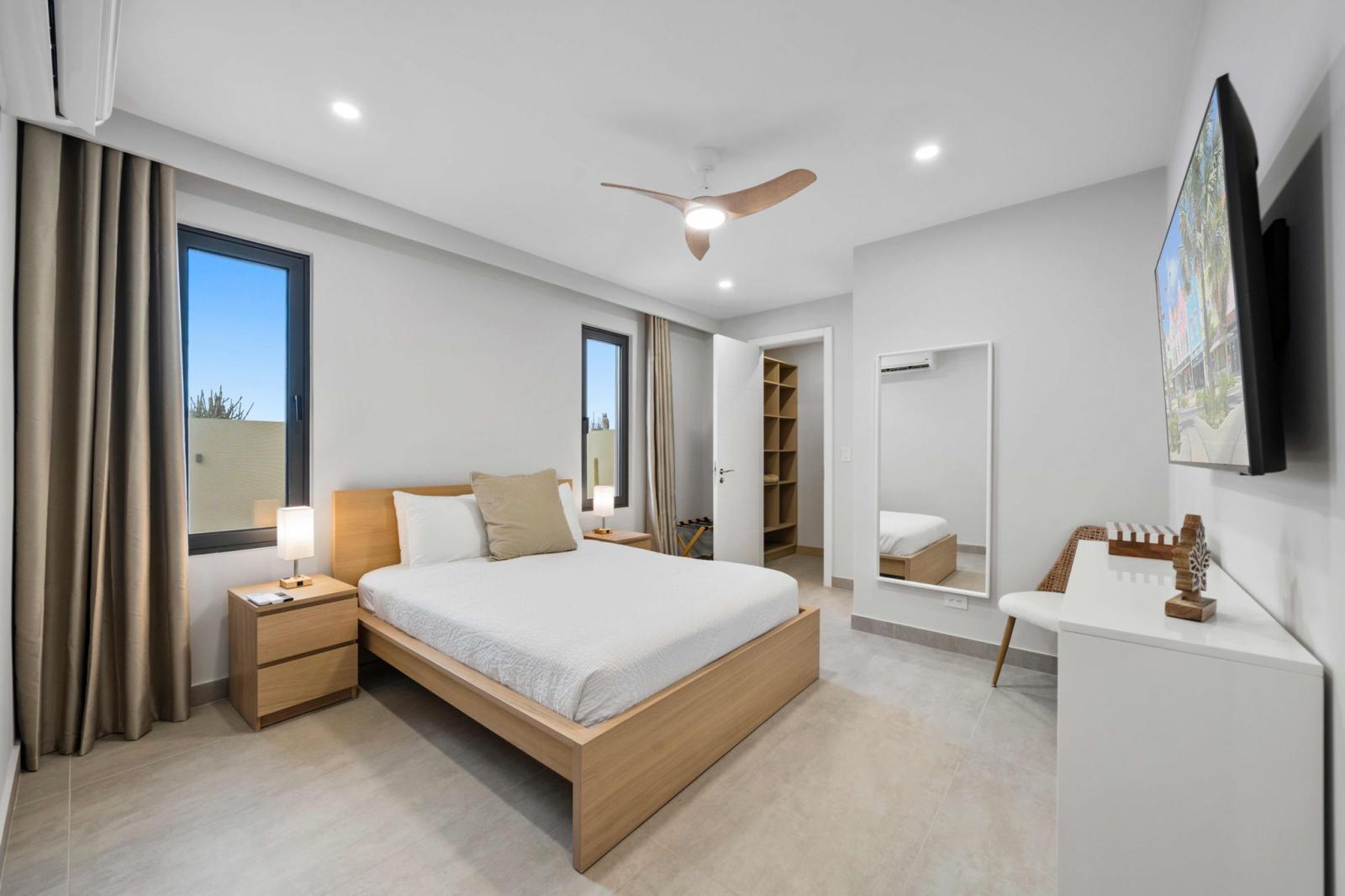 Peaceful bedroom with a comfy bed, soft lighting & a calming neutral design - Large windows bring in fresh air & natural light, creating a refreshing start to your day - Thoughtful details like a smart TV & walk in closet for a stress free stay