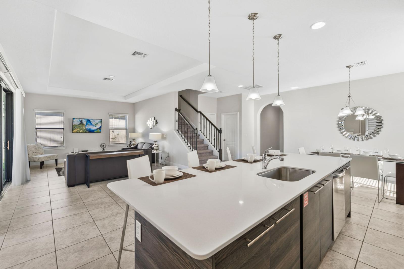 Spacious Kitchen & Open Living! The kitchen features a breakfast bar with seating for four and flows seamlessly into the living room with direct access to the pool.