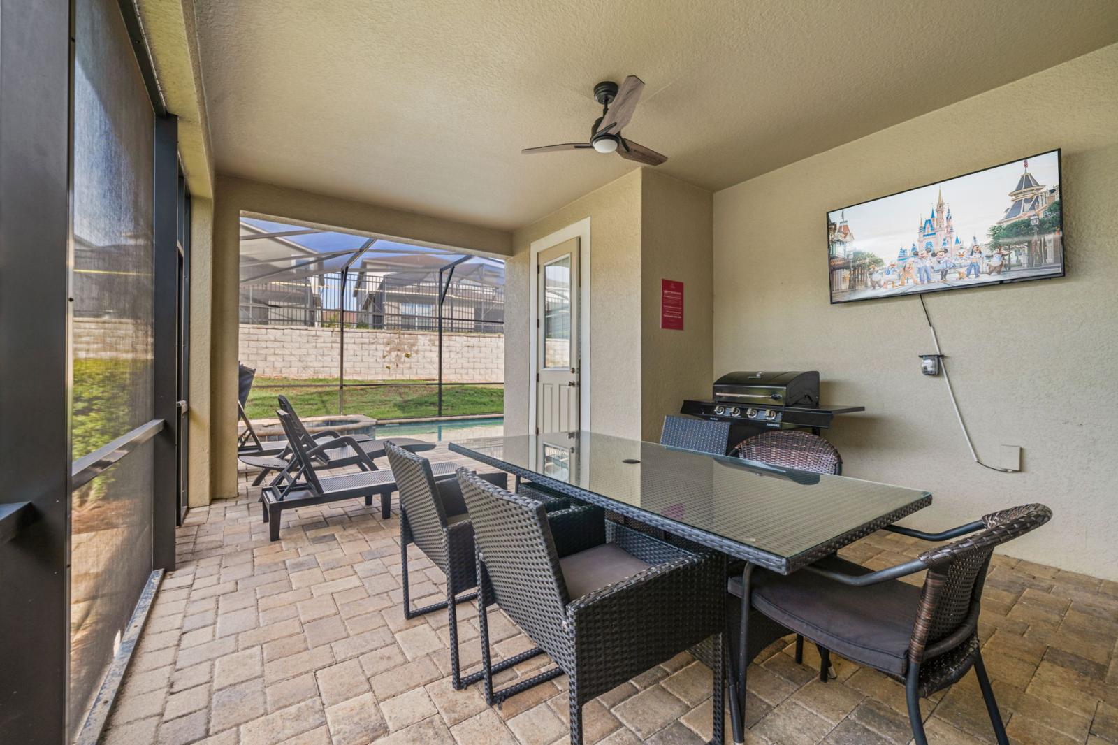 Sun-soaked patio with loungers, outdoor dining area  andgrill