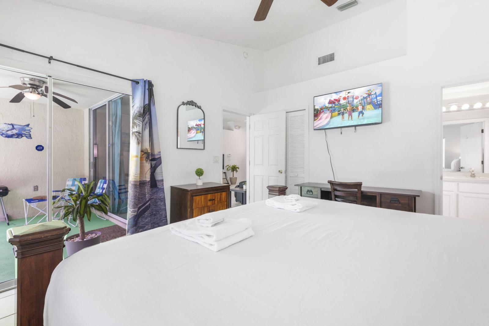 Primary bedroom retreat with direct access to the screened lanai, ensuite bathroom, and a cozy workstation—perfect for blending relaxation with remote work or planning your next adventure.