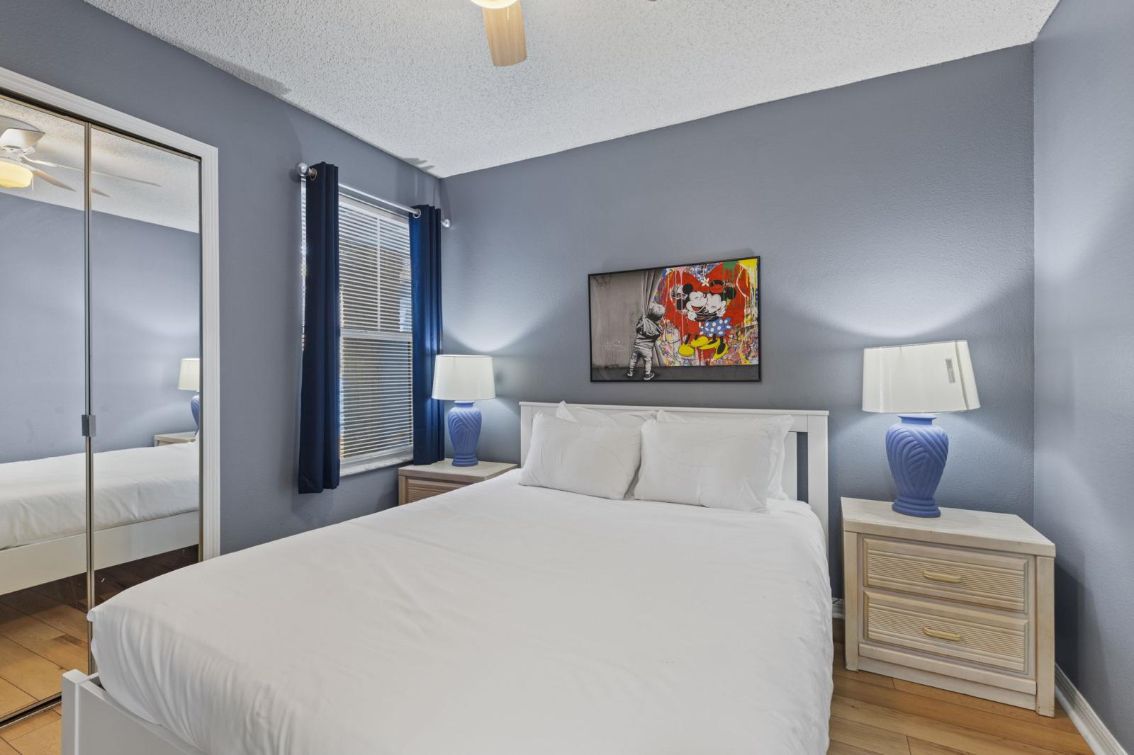 🛏️ Queen Bedroom with Disney Touches – A cozy retreat featuring a queen bed, mirrored closet, and whimsical Minnie art, perfect for adults or teens looking for a comfortable night’s sleep. #QueenRoom #RelaxAndRecharge #DisneyInspired