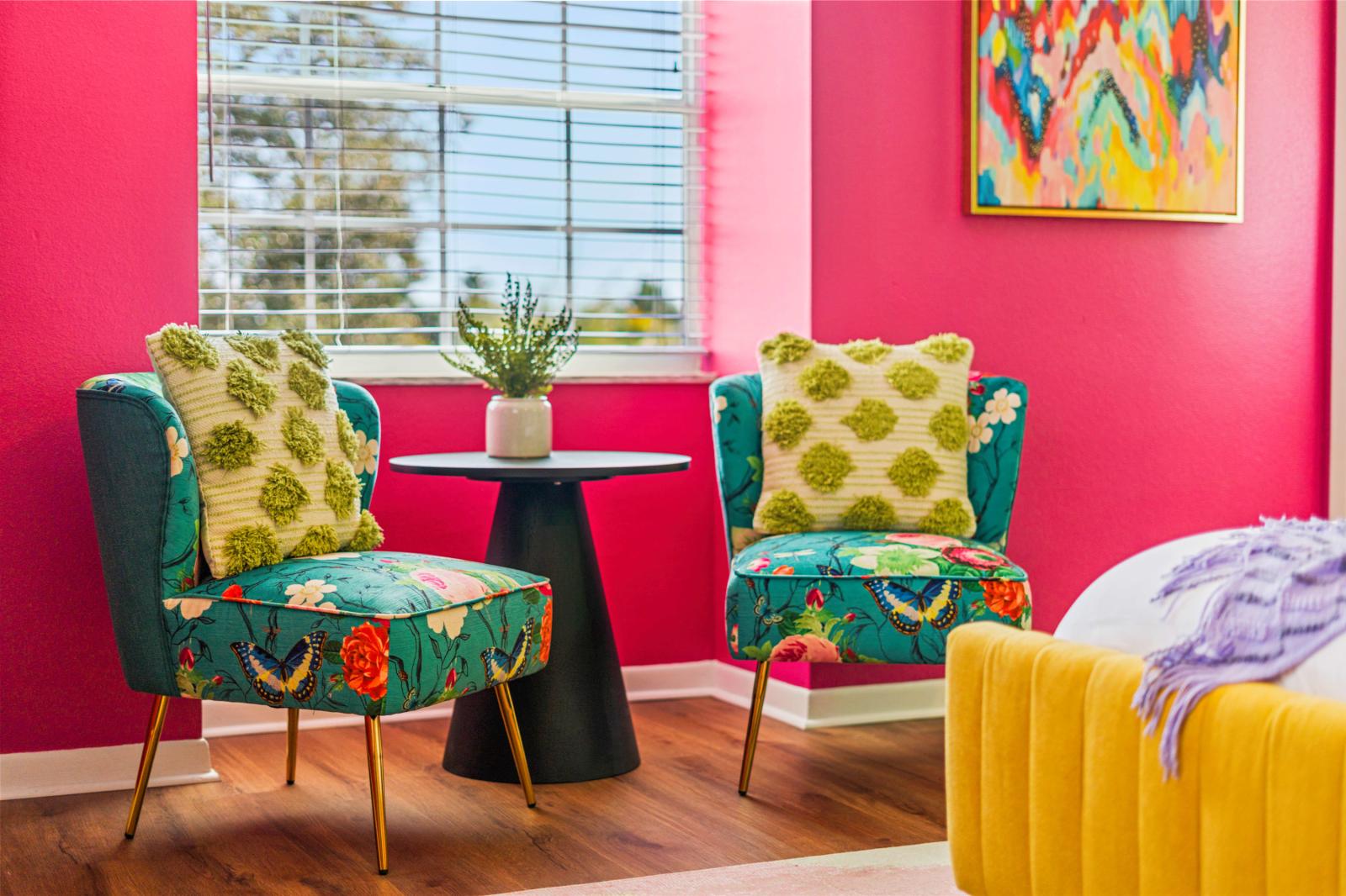 Luxurious primary bedroom with a king-size bed, a refreshing ceiling fan, and a large 65" smart TV, featuring an en-suite bathroom and a cozy reading corner for ultimate comfort and relaxation.