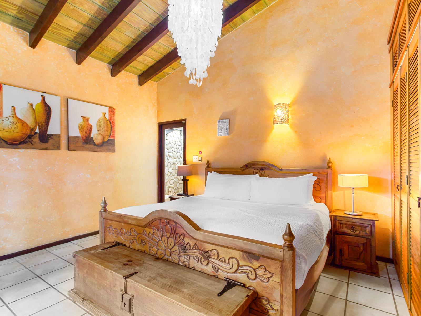 Luxurious master bedroom of the villa in Oranjestad Aruba - Comfy king size bed - Elegantly designed room beautifully decored with large aesthetic wall paintings - Majestic table lamps and elite chandelier - Neat and clean linen